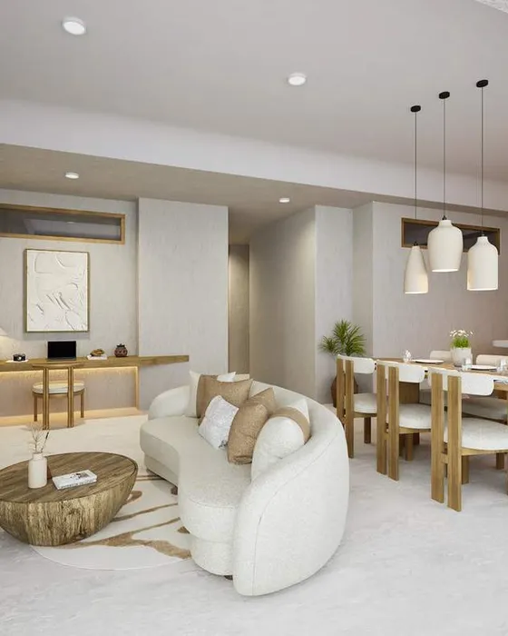 Living and dining room of a finished apartment, with a kitchen along the back wall.